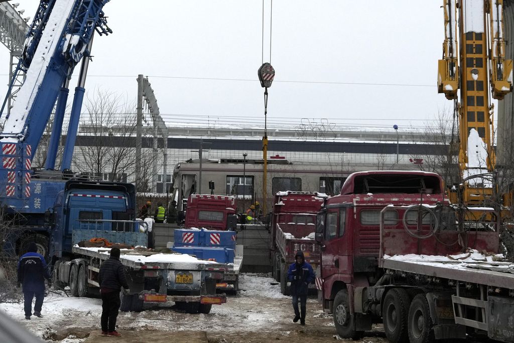 Sebuah penderek tengah dioperasikan di dekat gerbong di lokasi kecelakaan kereta api di barat Beijing, Jumat (15/12/2023). 