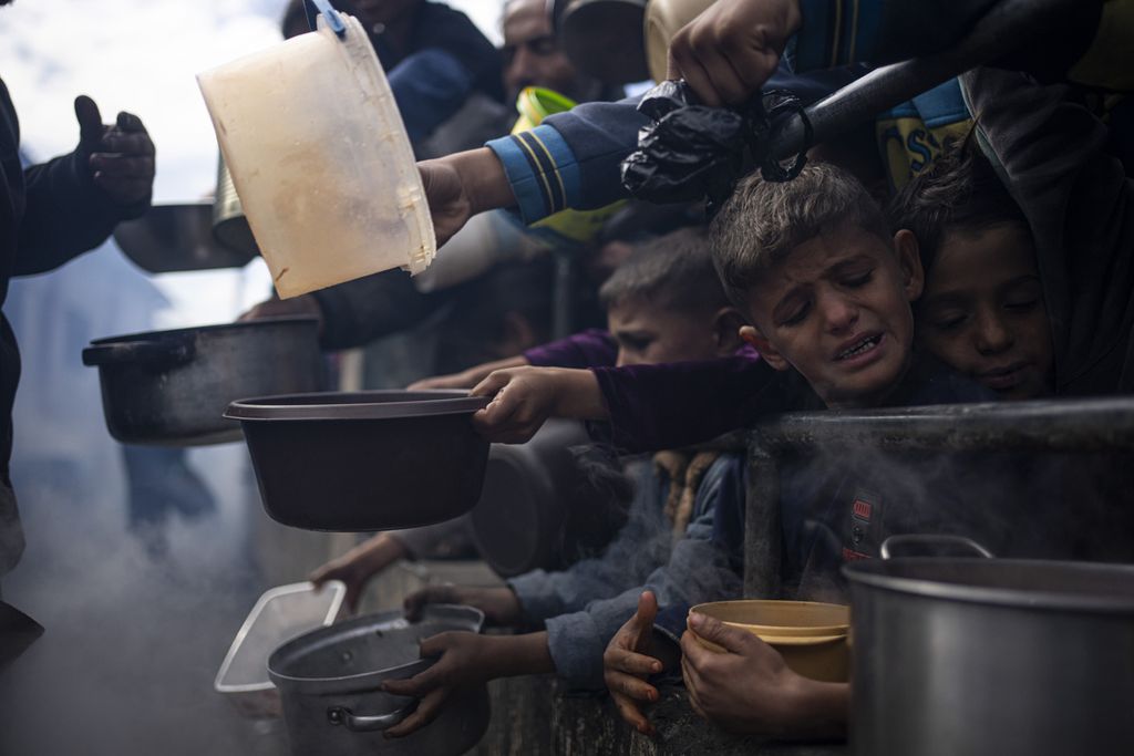 Anak-anak Palestina mengantre untuk mendapatkan makanan di Rafah, Jalur Gaza, 16 Februari 2024. 