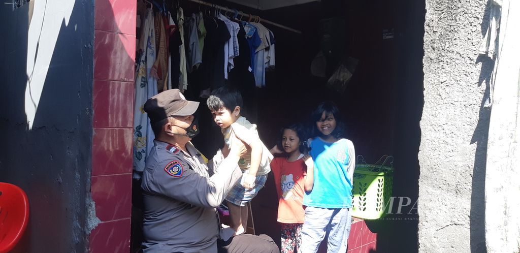 Seorang petugas Bhabinkamtibmas menjaga beberapa anak yang orangtuanya menjadi pelaku kekerasan dalam rumah tangga di Kelurahan Tanjung Duren Selatan, Grogol Petamburan, Jakarta Barat, Senin (23/5/2022).