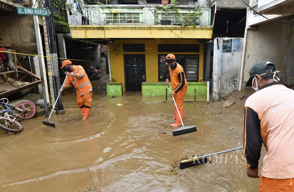 Petugas PPSU membersihkan lumpur sisa banjir di kawasan Rawajati, Pancoran, Jakarta Selatan, Selasa (9/2/2021). Banjir akibat luapan Sungai Ciliwung yang merendam permukiman warga di tiga RW di Kelurahan Rawajati tersebut berangsur surut. 