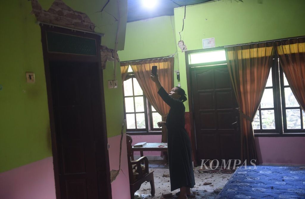 Melalui panggilan video dari kerabatnya, Rukayah menunjukkan bagian dinding rumahnya yang rusak oleh gempa di Desa Suwari, Kecamatan Sangkapura, Pulau Bawean, Kabupaten Gresik, Jawa Timur, Minggu (24/3/2024).