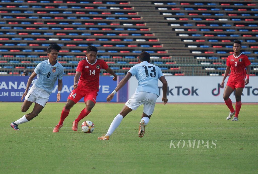Penyerang sayap kanan tim sepak bola Indonesia U-22, M Fajar Fathurrahman (tengah), menggiring. bola dengan dibayangi dua pemain Myanmar dalam laga di Stadion National Olympic, Kamis (4/5/2023). 