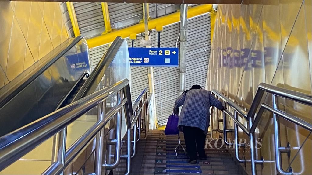 Seorang lansia disabilitas menaiki tangga manual karena eskalator di Stasiun Gondangdia, Jakarta, rusak, Rabu (13/9/2023).