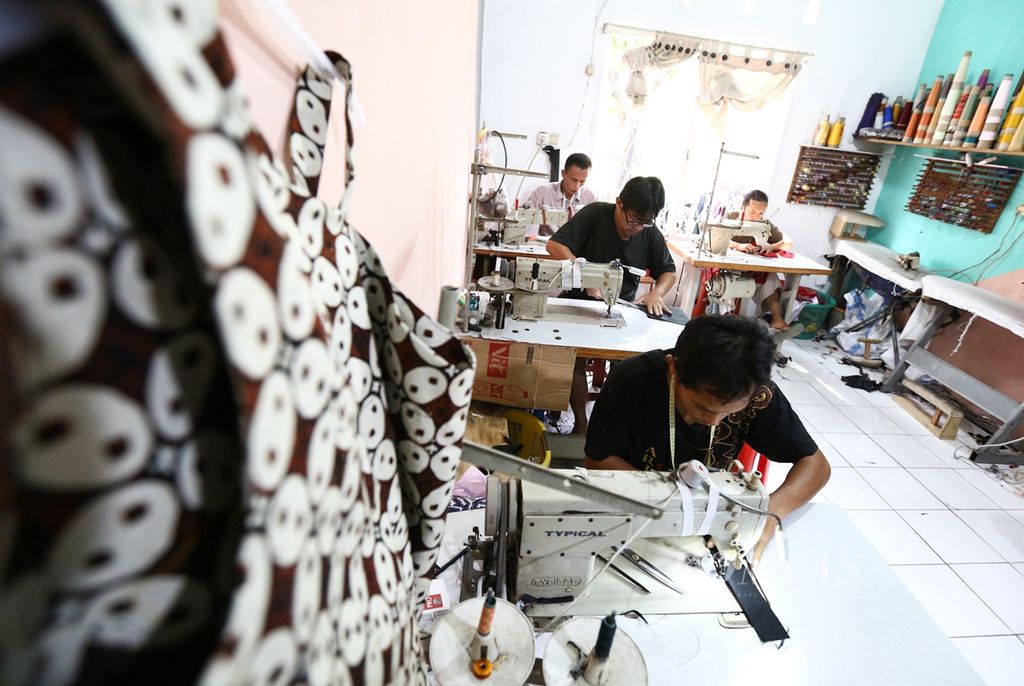 Pekerja memproduksi pakaian berbahan kain batik di usaha mikro kecil dan menengah (UMKM) Dewi Sambi di kawasan Larangan, Kota Tangerang, Banten, Sabtu (14/9/2019). UMKM tersebut mampu memproduksi 1000 potong pakaian batik berbagai model yang dijual hingga pasar Singapura dan Malaysia. Perkembangan bisnis digital turut membantu UMKM dalam memasarkan produk mereka. 