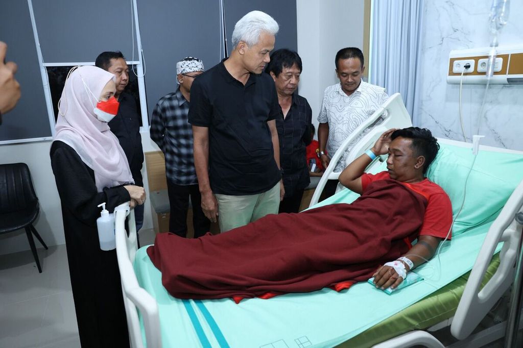 Capres nomor urut 3 Ganjar Pranowo (ketiga dari kiri) bersama istrinya, Siti Atikoh (kiri), menjenguk sukarelawan pendukung Ganjar-Mahfud yang menjadi korban penganiayaan, di RSUD Pandan Arang, Kabupaten Boyolali, Jawa Tengah, Minggu (31/12/2023) malam. Penganiayaan diduga dilakukan oleh oknum TNI ketika para sukarelawan sedang konvoi. Ada dua sukarelawan yang masih dirawat di rumah sakit sehubungan dengan kasus penganiayaan itu.