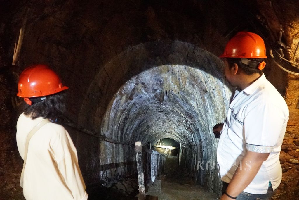 Pemandu wisata (kanan) memberikan penjelasan kepada pengunjung terkait Lubang Tambang Mbah Soero, salah satu peninggalan tambang batubara Ombilin di Kota Sawahlunto, Sumatera Barat, Rabu (22/6/2022).