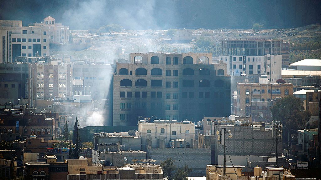 Asap mengepul  dari balik sebuah gedung di ibu kota Yaman, Sana\'a, Minggu (3/12), saat berlangsung pertempuran antara milisi Houthi dan pasukan loyalis mantan Presiden Yaman Ali Abdullah Saleh.