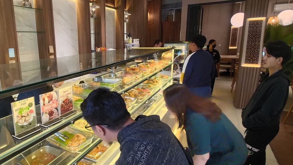 Pekerja berbahasa Indonesia sedang antre di TAMBUAH Indonesian Padang Cuisine, rumah makan padang yang berlokasi di HP Avenue, Sihanoukville, Kamboja, awal Desember 2023.