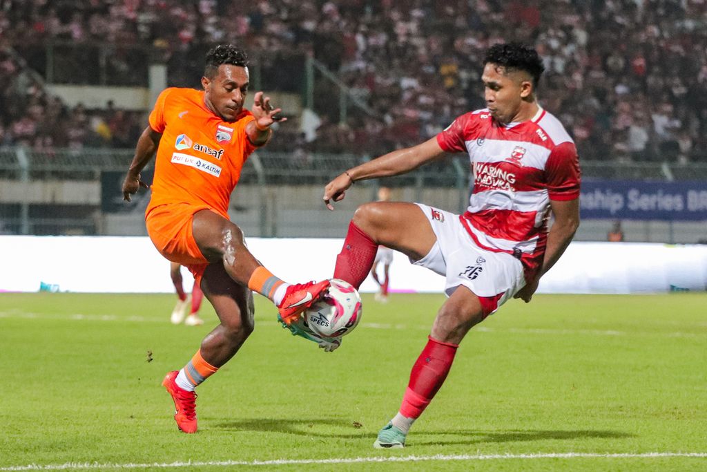 Pemain Madura United, Dodi Alekvan Djin (kanan), berebut bola dengan pemain Borneo FC, Terens Puhiri, pada laga pertama semifinal Championship Series Liga 1 di Stadion Gelora Bangkalan, Rabu (15/5/2024).