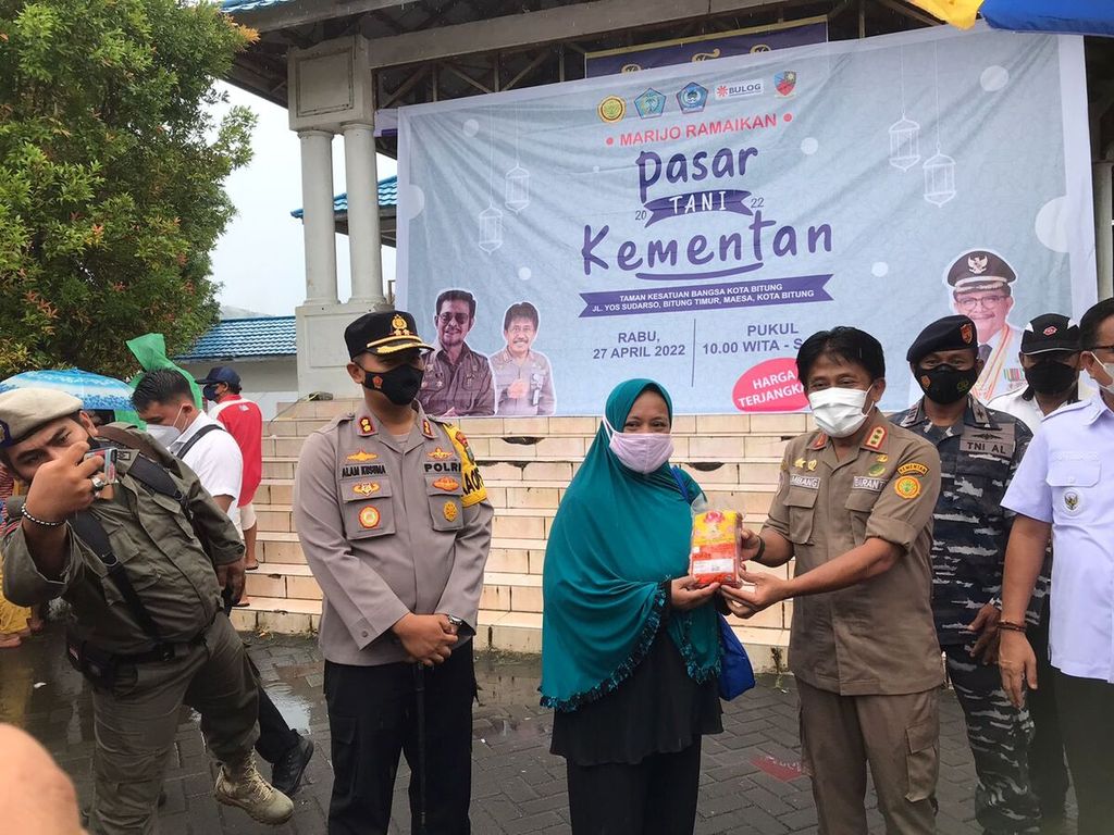 Kepala Badan Karantina Pertanian Bambang menyerahkan bahan pangan secara simbolik kepada pengunjung Pasar Tani Ramadhan di Taman Kesatuan Bangsa Bitung, Sulawesi Utara, Rabu (27/4/2022).
