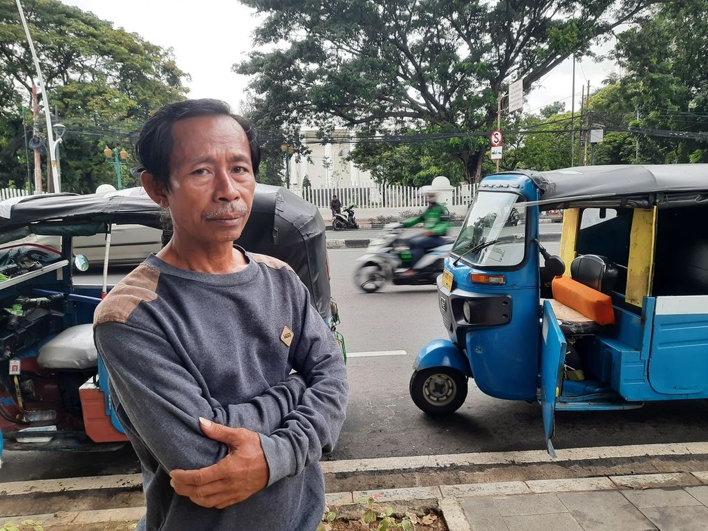 Sopir bajaj Kumedi (52) yang sehari-hari menunggu penumpang di depan Stasiun Gambir, Jakarta, Rabu (1/3/2023). 