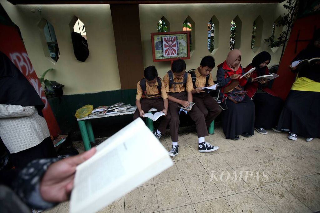 Sejumlah anak SMP sedang membaca buku yang dipinjamkan secara gratis oleh Komunitas Rindu Menanti di Halte SMP 6 Cimahi, Kota Cimahi, Jawa Barat, Sabtu (13/2/2017). Komunitas Rindu Menanti memberikan buku pinjaman secara gratis untuk meningkatkan minat baca dan mendorong penggunaan transportasi umum. 