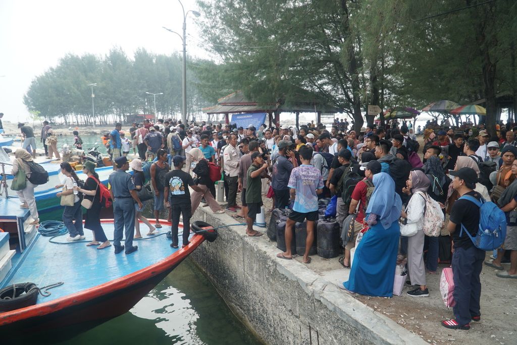 Pengunjung memadati dermaga untuk naik kapal motor untuk meninggalkan Pulau Pari, Kabupaten Kepulauan Seribu, Jakarta, Senin (1/1/2024).