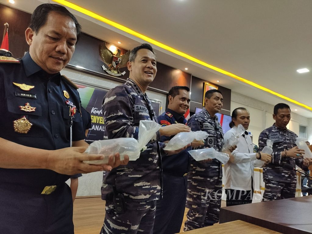 Sejumlah pejabat dari instansi terkait memegang barang bukti benih bening lobster (BBL) yang akan diselundupkan ke Singapura seusai konferensi pers di Pangkalan TNI AL Palembang, Sumatera Selatan, Senin (6/5/2024).  