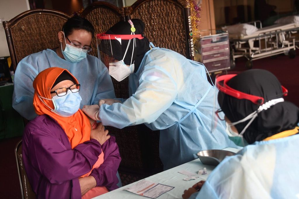 Tenaga medis menjalani vaksinasi tahap kedua di RS Husada Utama, Surabaya, Jawa Timur, Senin (8/2/2021). Indonesia memulai vaksinasi untuk warga usia lanjut yang berprofesi sebagai tenaga medis dengan usia di atas 60 tahun dengan target 11.603 nakes. Di RS Husada Utama tersebut dilakukan vaksinasi tahap pertama kepada 22 nakes usia lanjut dan vaksinasi tahap kedua kepada 107 nakes.