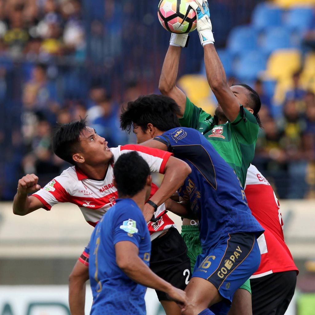Kiper Madura United Hery Prasetyo (kanan) menggagalkan upaya duel bek Persib Bandung Ahmad Jufriyanto (tengah) dalam Go-Jek Traveloka Liga 1 di Stadion Si Jalak Harupat, Bandung, Jawa Barat, Kamis (19/10). Laga Persib melawan Madura United ini berakhir imbang 0-0.