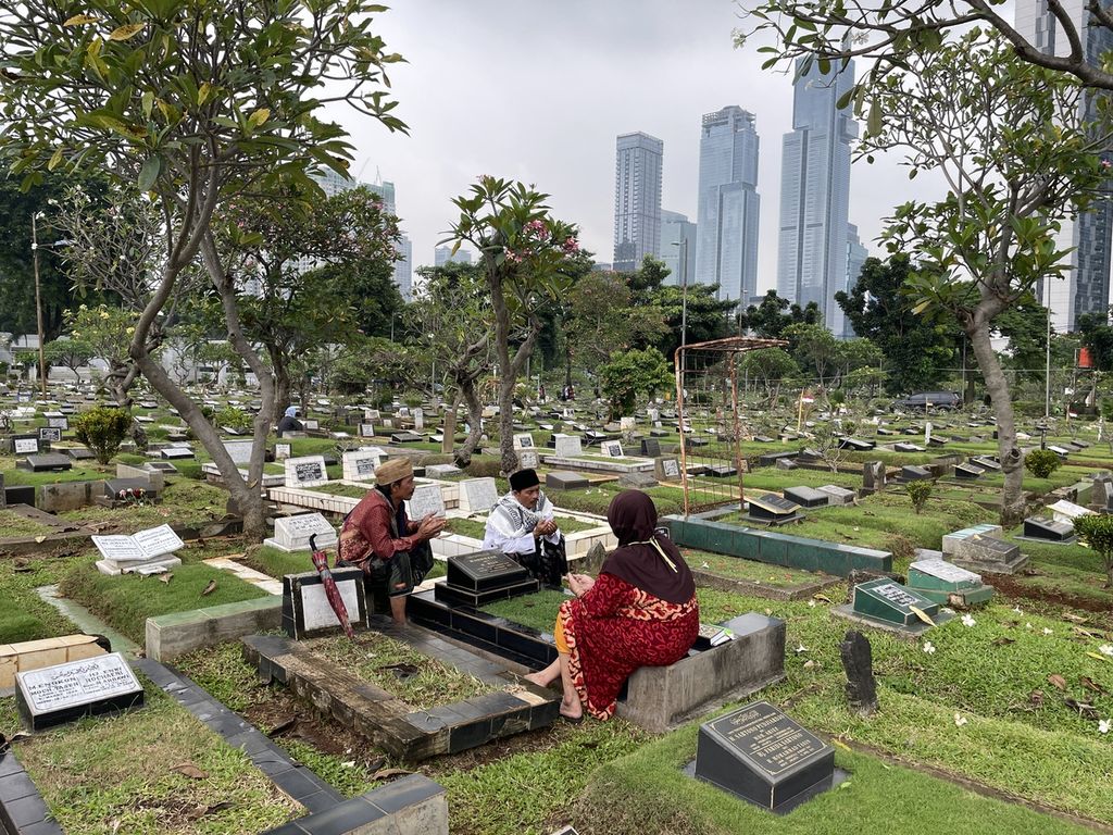 Husen Maksum (kiri) dan saudara kembarnya, Hasan Mahmud, memimpin doa untuk arwah keluarga peziarah di Taman Pemakaman Umum Karet Bivak, Jakarta Pusat, Rabu (15/3/2023).