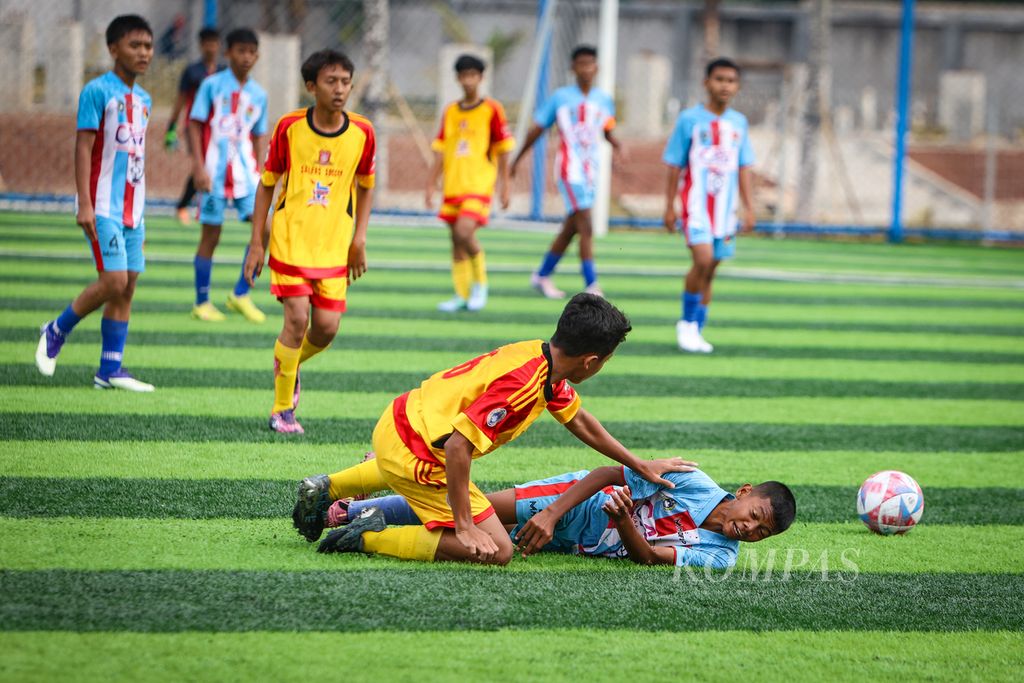 Pemain Salfas Soccer, Muhammad Hayyu Al-Fayiz (kiri), dan pemain Remci FC, Muhammad Fauzan Ardiansyah, terjatuh saat berebut bola dalam laga babak <i>playoff </i>Liga <i>Kompas</i> Kacang Garuda U-14 di Dewantara Sport Center, Tangerang Selatan, Banten, Minggu (12/11/2023). Salfas Soccer lolos ke babak utama setelah menahan imbang Remci FC dengan skor 0-0. 