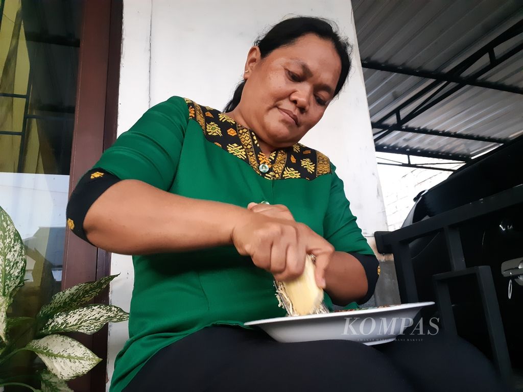 Tuti Lawalu (43) memarut buah pisang rebus sebagai pengganti nasi untuk makan malam pada Selasa (21/3/2023). Sudah lebih dari satu tahun warga Kota Kupang, Nusa Tenggara Timur, itu tidak lagi mengonsumsi nasi. 