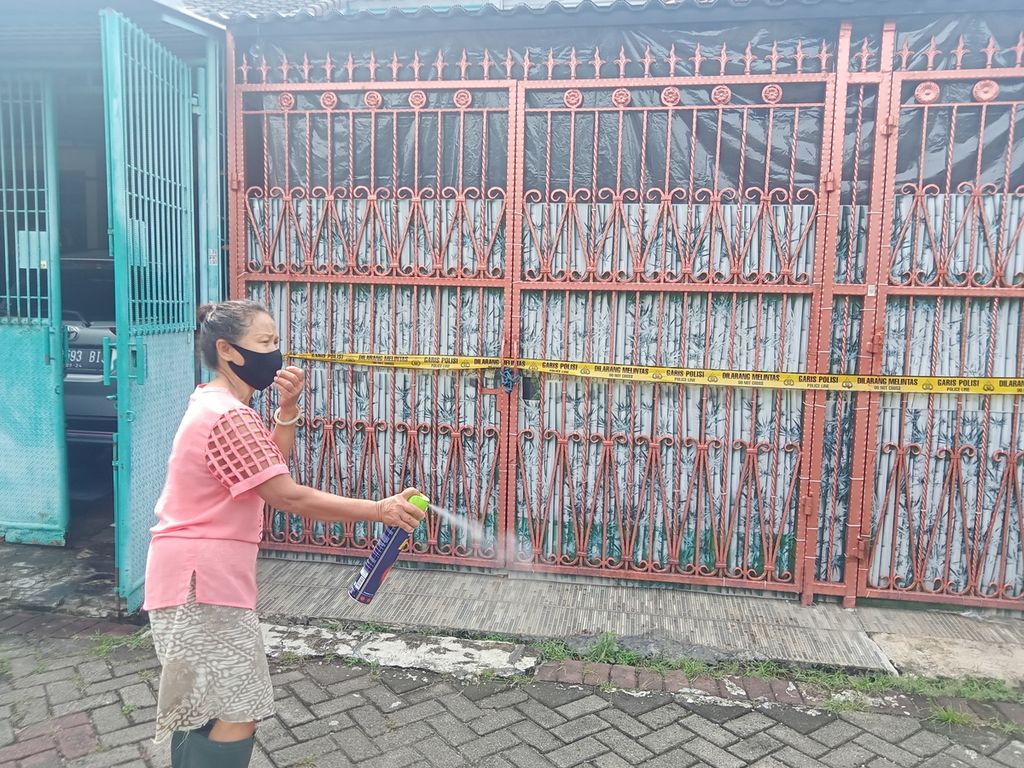 Tio Siu Hoa (68) sedang menyemprotkan semprotan antiserangga di depan rumahnya dan rumah keluarga yang mati secara misterius di kompleks Citra Garden 1, Kalideres, Jakarta Barat, Minggu (13/11/2022). Ia mengaku masih mencium sisa-sisa bau menyengat dari rumah TKP tersebut.