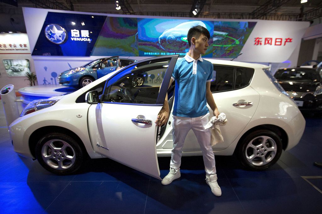 Foto yang diambil pada 25 April 2016 memperlihatkan seorang staf pemasaran keluar dari kabin depan mobil produksi pabrikan otomotif China, Venucia, yang dipamerkan di Beijing International Automotive Exhibition di Beijing, China. 