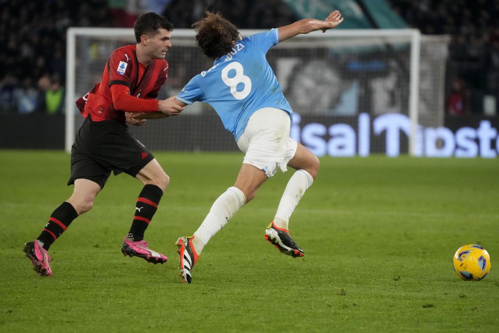 Penyerang sayap AC Milan Christian Pulisic (kiri) mencoba menghambat gelandang Lazio Matteo Guendouzi dalam pertandingan Liga Italia antara Lazio dan AC Milan di Stadion Olympic, Roma, Sabtu (2/3/2024). 