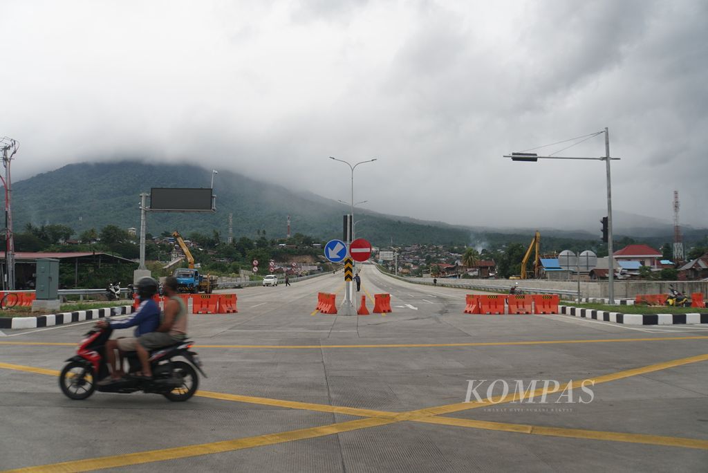 Pengendara melintas di ujung timur Jalan Tol Manado-Bitung di seberang Terminal Peti Kemas Bitung, Sulawesi Utara, Jumat (21/1/2022).
