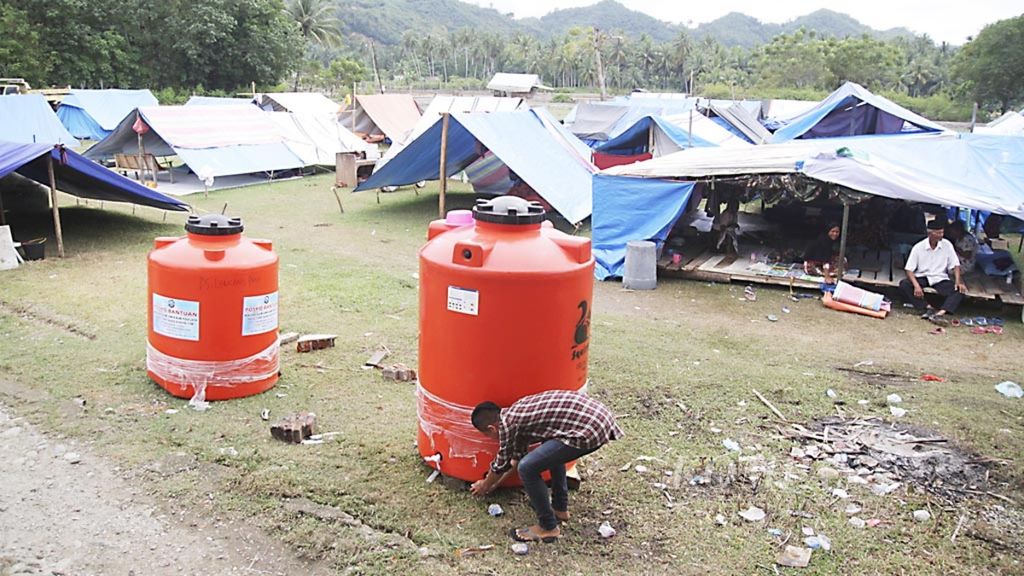 Warga korban gempa Aceh menggunakan stok air bersih untuk masak dan wudu di posko pengungsian Gampong Lancang Paru, Kecamatan Bandar Baru, Kabupaten Pidie Jaya, Provinsi Aceh, Kamis (22/12/2016). 