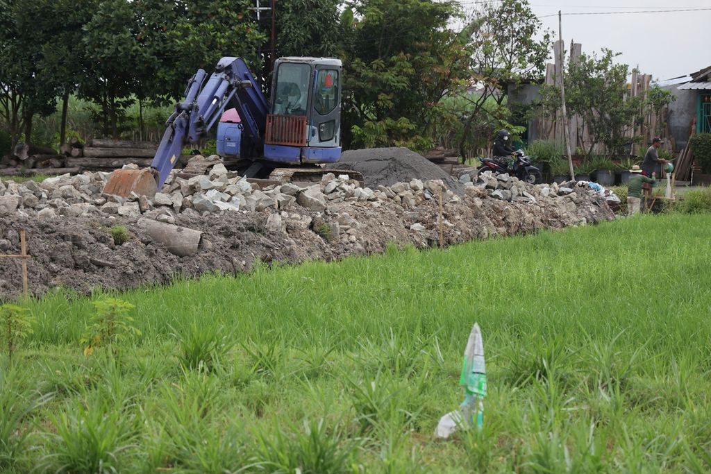 Alat berat disiapkan di atas bekas sebuah petak sawah yang sedang dialihfungsikan di Kecamatan Sewon, Bantul, DI Yogyakarta, Rabu (18/1/2023). Alih fungsi lahan pertanian menjadi ancaman terhadap pencapaian ketahanan dan keamanan pangan. Pemerintah menetapkan luas lahan pertanian pangan berkelanjutan di Kabupaten Bantul seluas 14.407,50 hektar sebagai bagian upaya memperlambat laju alih fungsi lahan pertanian.