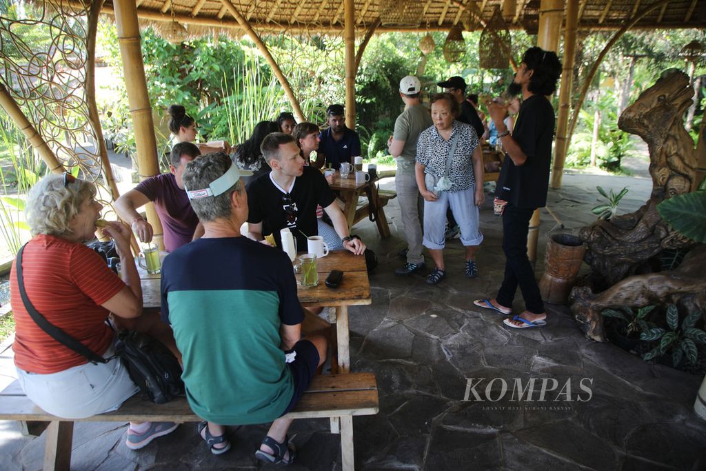 Wisatawan mancanegara istirahat sejenak sembari menikmati makanan dan minuman lokal di sebuah tempat penginapan dan resto di Dusun Tempasan Pringgasela, Kecamatan Pringgasela, Kabupaten Lombok Timur, Nusa Tenggara Barat, Selasa (19/12/2023). 