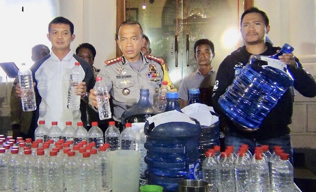 Petugas Polrestabes Surabaya menunjukkan barang bukti minuman keras oplosan yang diamankan dari tiga pedagang dan produsen di Surabaya, Minggu (23/4/2018). 