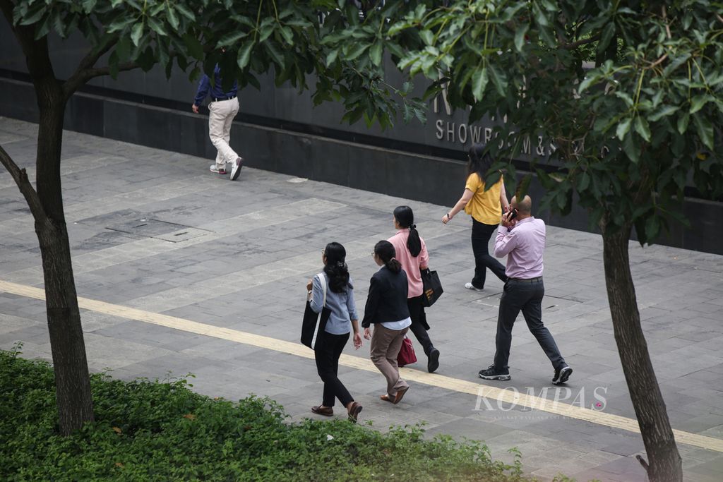 Karyawan berjalan menyusuri jalur pedesterian di Jalan Jenderal Sudirman, Jakarta, saat jam istirahat siang, Selasa (21/11/2023). Sejumlah kota di Indonesia mulai merilis besaran upah minimum provinsi (UMP) tahun 2024. 