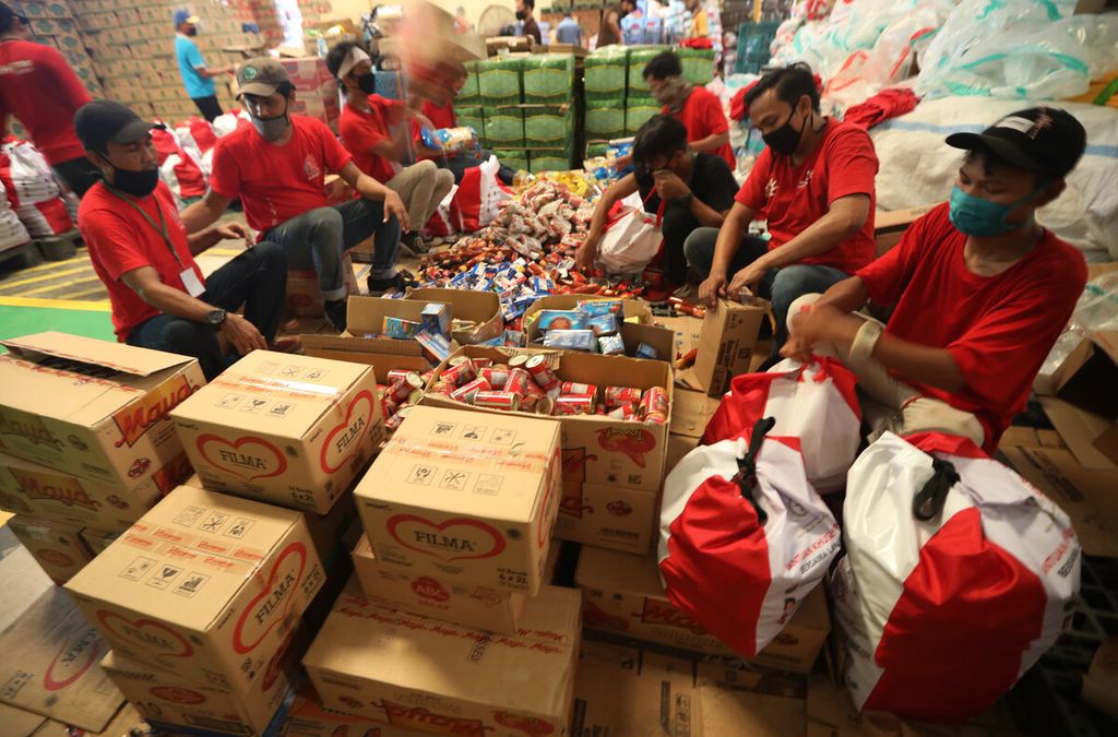 Pekerja mengemas paket bantuan sosial (bansos) di Gudang PT Food Station Tjipinang Jaya, Cipinang, Jakarta Timur, Kamis (23/4/2020). 