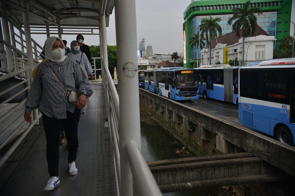 Warga berjalan menuju tempat pemberhentian bus Transjakarta di Halte Harmoni, Jakarta Pusat, 16 Desember 2022.