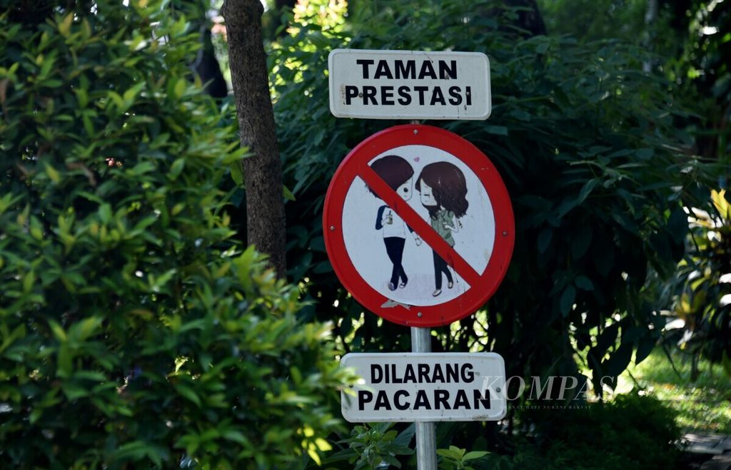 Rambu larangan berpacaran di Taman Prestasi, Surabaya, Minggu (23/6/2019). Taman-taman kota yang terjaga di musim kemarau tidak hanya sebagai tempat bermain, tetapi juga tempat warga melakukan interaksi sosial.
