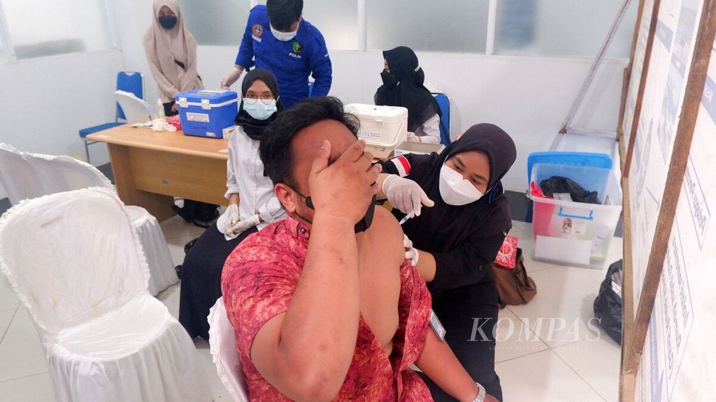 Petugas kesehatan menyuntikkan vaksin dosis ketiga atau penguat (<i>booster</i>) kepada warga di Terminal Tipe A Gambut Barakat, Kabupaten Banjar, Kalimantan Selatan, Selasa (15/3/2022).
