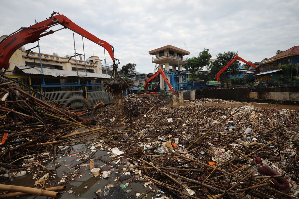 Ekskavator yang dioperasikan petugas Unit Pelaksana Kebersihan Badan Air membersihkan tumpukan sampah Kali Ciliwung di pintu air Manggarai, Jakarta Selatan, Selasa (22/9/2020).