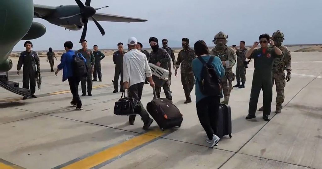 Sejumlah warga Korea Selatan berjalan menuju pesawat militer di Bandara Port Sudan, 24 April 2023, untuk dievakuasi ke Jeddah, Arab Saudi. 