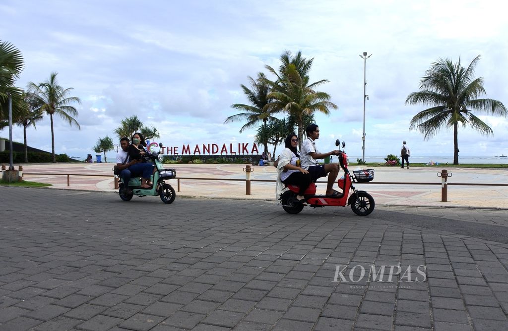 Wisatawan melintasi Land Mark The Mandalika di kawasan Pantai Kuta, Pujut, Lombok Tengah, Nusa Tenggara Barat, Kamis (8/2/2024) siang. Mandalika saat ini menjadi salah satu Kawasan Ekonomi Khusus atau destinasi superprioritas pariwisata yang dikembangkan pemerintah sejak 2014 lalu. Sejumlah kegiatan bertaraf internasional digelar seperti balap MotoGP.