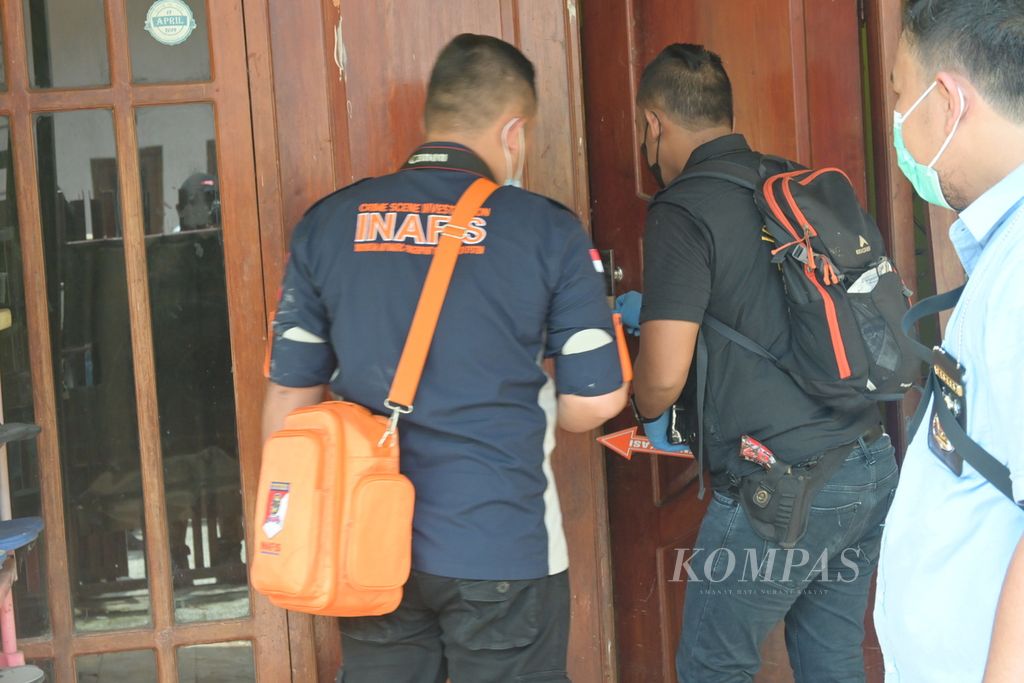 Petugas membuka pintu rumah kontrakan di Harapan Jaya, Bekasi Utara, tempat ditemukan dua perempuan yang dikubur dengan coran semen, Selasa (28/2/2023) siang.