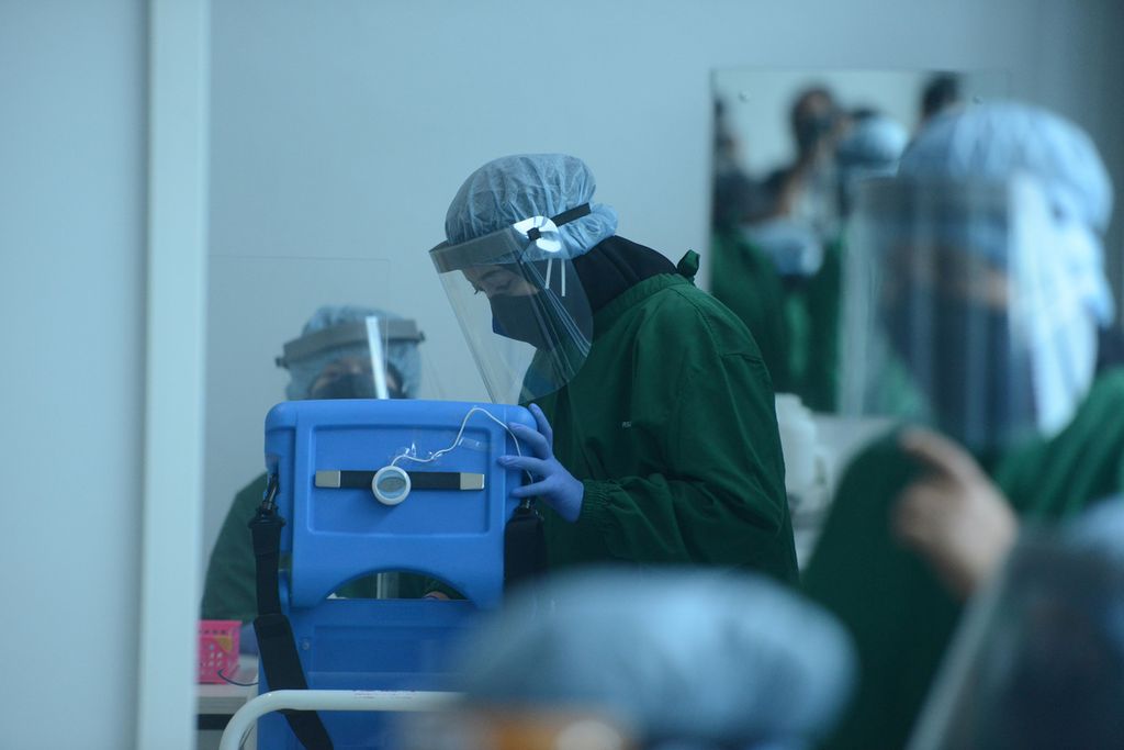 Petugas medis memeriksa vaksin Sinovac yang akan disuntikkan ke penerima vaksin di Rumah Sakit Umum Daerah Bung Karno, Solo, Jawa Tengah, Kamis (14/1/2021). 