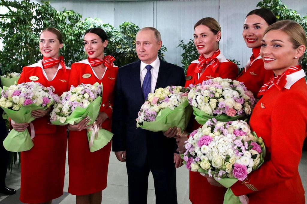 Presiden Rusia Vladimir Putin (tengah) berfoto bersama para karyawan Aeroflot saat ia mengunjungi kompleks pelatihan penerbangan Aeroflot di luar Moskwa, Ukraina, Sabtu (5/3/2022). 