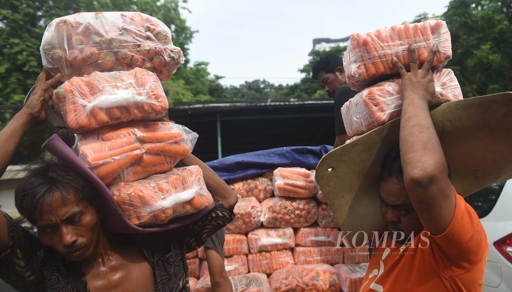 Pekerja membawa wortel yang baru tiba di Pasar Keputran Utara, Surabaya, Jawa Timur, Rabu (14/2/2024). 