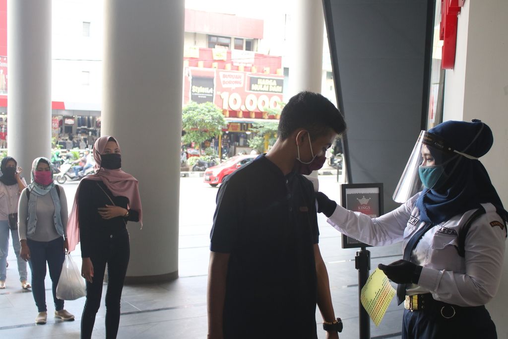 Petugas keamanan memeriksa pengunjung di pintu masuk The Kings Shopping Centre di Jalan Kepatihan, Bandung, Senin (15/6/2020).