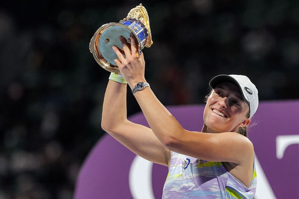 Petenis Polandia, Iga Swiatek, mengangkat trofi sebagai juara WTA 1000 Doha 2022 di Khalifa International Tennis Squash Complex, Doha, Qatar, 26 Februari 2022. Swiatek tiga kali menjuarai turnamen WTA 1000 Doha, yakni pada tahun 2022, 2023, dan 2024.