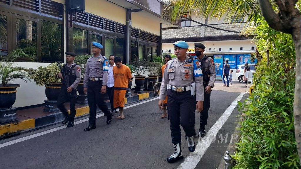 Polisi mengawal dua pelaku pembunuhan sopir taksi daring di Kepolisian Resor Malang, Jawa Timur, Kamis (8/7/2023).