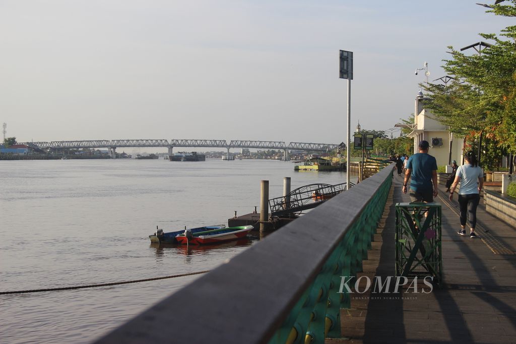 Warga berolahraga di tepian Sungai Kapuas, Kota Pontianak, Kalimantan Barat, Minggu (14/7/2024).