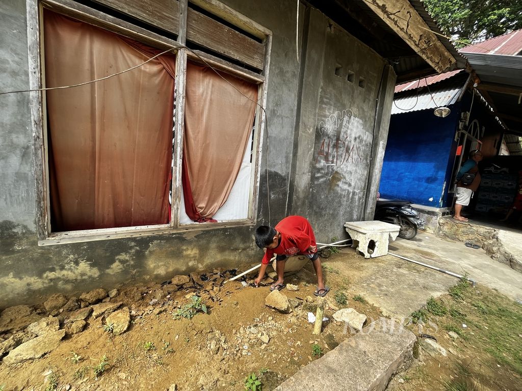 Seerang anak memungut kaca jendela yang pecah akibat getaran ledakan di Mako Ditpolairud Polda Sultra pecah, pada Kamis (8/9/2022) dini hari, di Kendari, Sulawesi Tenggara. Ledakan terjadi di gudang penyimpanan barang bukti, yang juga membuat sejumlah kerusakan di rumah warga.