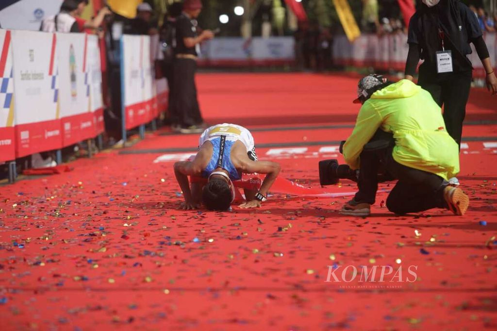 Pelari Nurshodiq melakukan sujud syukur setelah berhasil menjadi pelari putra tercepat dalam lomba lari Elite Race Borobudur Marathon 2022 Powered by Bank Jateng, Sabtu (12/11/2022), di kawasan Borobudur, Kabupaten Magelang, Jawa Tengah.