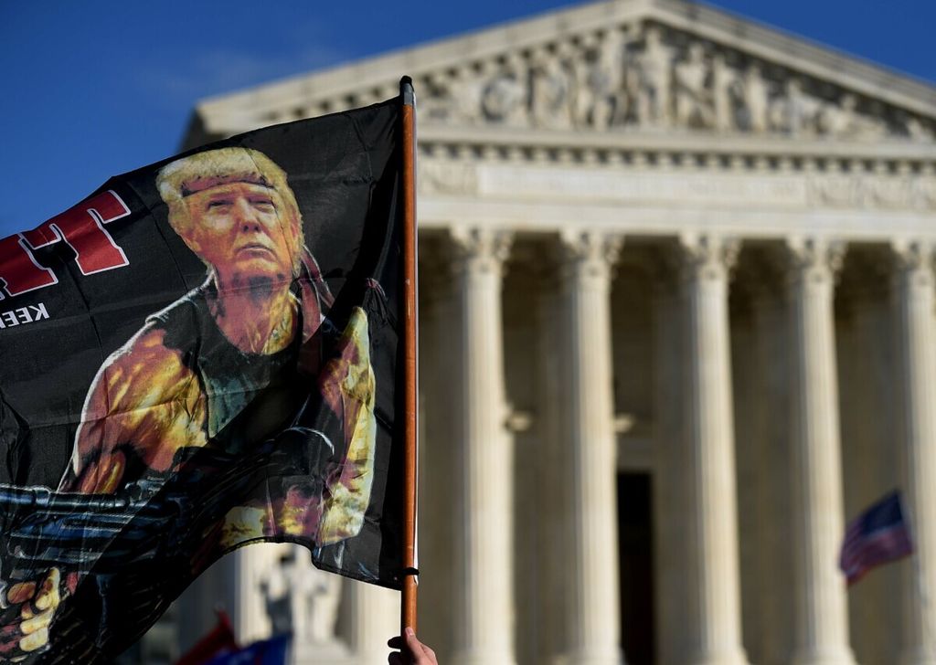 Pendukung Presiden AS Donald Trump membawa gambar Trump sebagai Rambo dalam Million MAGA March untuk memprotes hasil pemilihan presiden tahun 2020 di depan Mahkamah Agung AS, Sabtu (12/12/2020).